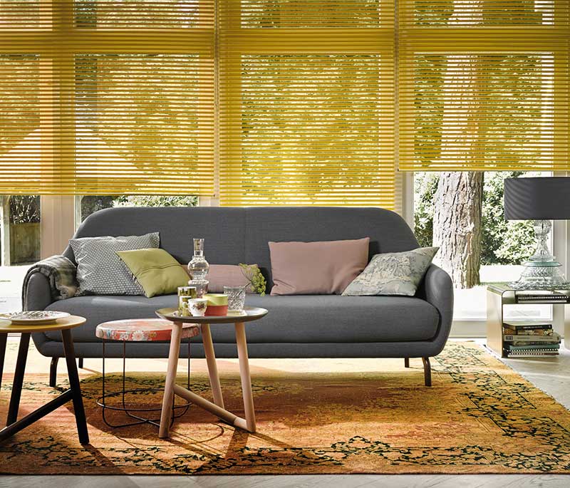 stores jaune dans un salon avec canapé gris