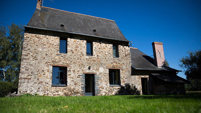 maison en pierre avec menuiseries design et fenêtres exposées au Sud