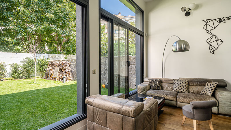 baies vitrées en aluminium dans le salon maison moderne avec vue sur le jardin