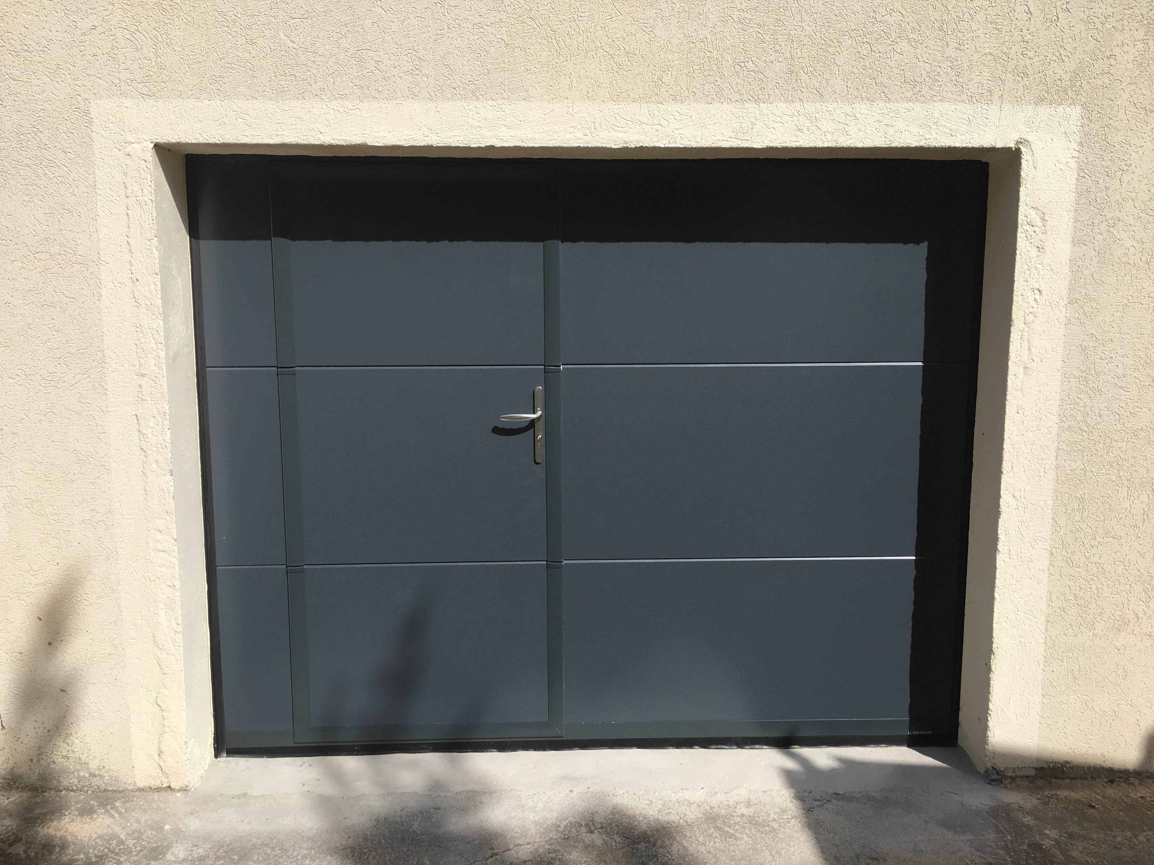 Porte de garage sectionnelle isolée en acier avec portillon intégré Montpellier Komilfo